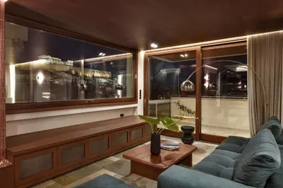 a living room with a couch and a large window at KARYATIS LUXURY MAISONETTE by K&K in Athens