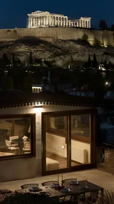 a building with a table and chairs in front of a building at KARYATIS LUXURY MAISONETTE by K&K in Athens