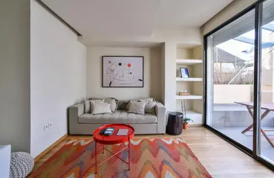 a living room with a couch and a red stool at Kolonaki Boutique Apartments by Olala Homes in Athens