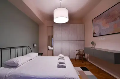 a bedroom with two beds and a table in it at Kolonaki Boutique Apartments by Olala Homes in Athens
