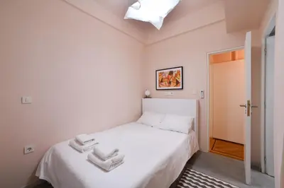 a small bedroom with a white bed and a ceiling at Kolonaki Boutique Apartments by Olala Homes in Athens
