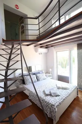 a bedroom with a bunk bed and a spiral staircase at Thimari Sports & Spa with private pool and jacuzzi in Sounio