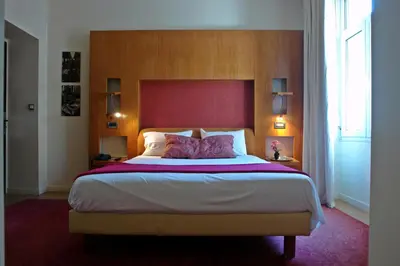 a bedroom with a large bed with a red headboard at Semeli Hotel in Athens
