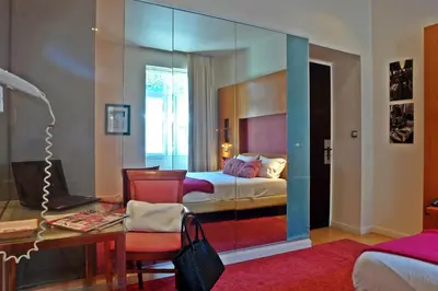 a bedroom with a bed and a desk and a mirror at Semeli Hotel in Athens