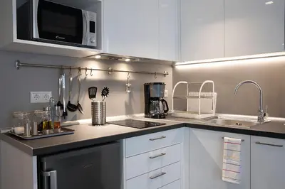 a kitchen with white cabinets and a sink and a microwave at Homz Studios Neapolis in Athens
