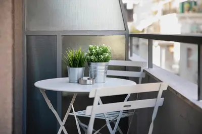 a small white table and two plants on a balcony at Homz Studios Neapolis in Athens