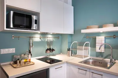 a kitchen with a sink and a microwave at Homz Studios Neapolis in Athens