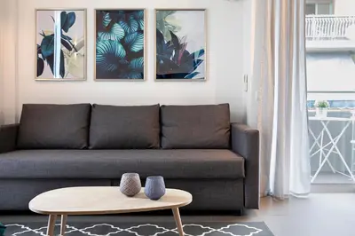 a living room with a couch and a table at Homz Studios Neapolis in Athens