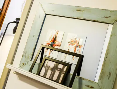 a mirror with a wooden frame on a shelf at 5inAthens in Athens