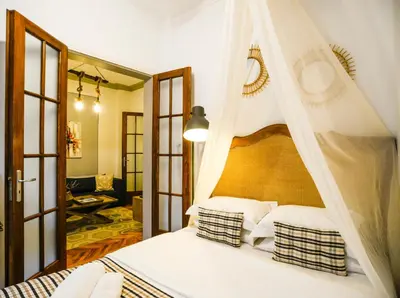 a bedroom with a canopy bed and a living room at 5inAthens in Athens