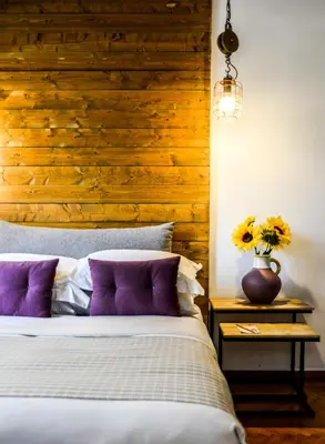 a bedroom with a bed and a wooden wall at 5inAthens in Athens