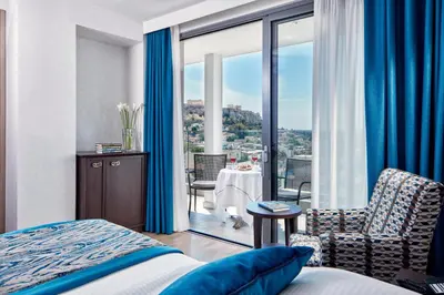 a hotel room with a bed and a view of the city at Electra Metropolis in Athens