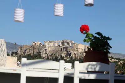 a flower in a vase on a table with the acropolis at Live in Athens, THISEIO Residency, Our first love #01 in Athens