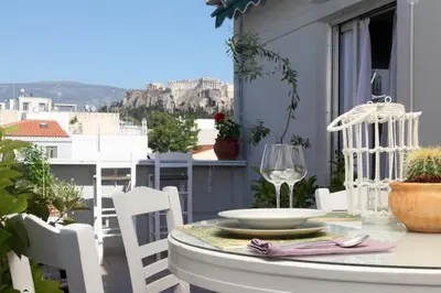 a table and chairs on a balcony with a view of the city at Live in Athens, THISEIO Residency, Our first love #01 in Athens