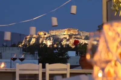 a view of the acropolis from a table with wine glasses at Live in Athens, THISEIO Residency, Our first love #01 in Athens