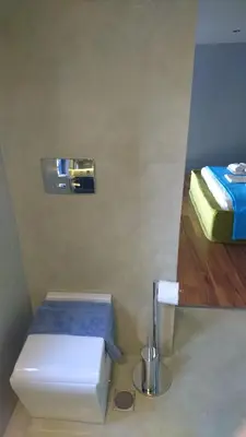 a small bathroom with a toilet and a bed at Athina Art Apartments in Athens