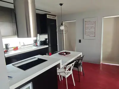 a kitchen with a white counter and a table and chairs at Athina Art Apartments in Athens