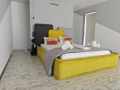 a bedroom with a large bed with a yellow headboard at Athina Art Apartments in Athens
