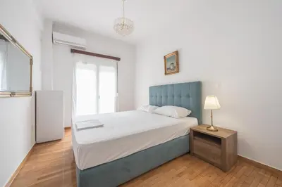 a bedroom with a bed with a blue headboard at Victoria Secret Apartments in Athens