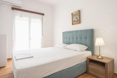 a bedroom with a large bed with a blue headboard at Victoria Secret Apartments in Athens