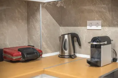 a kitchen counter with a coffee maker and a toaster at Victoria Secret Apartments in Athens