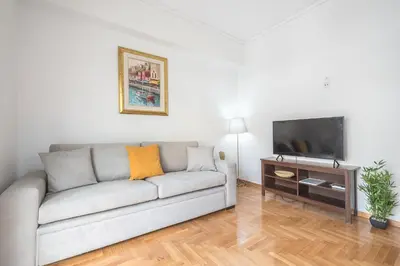 a living room with a couch and a flat screen tv at Victoria Secret Apartments in Athens