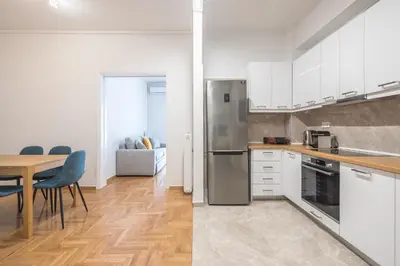 a kitchen with a stainless steel refrigerator and a table at Victoria Secret Apartments in Athens