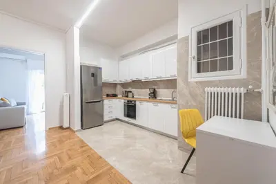 a kitchen with a stainless steel refrigerator and white cabinets at Victoria Secret Apartments in Athens