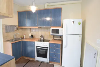 a kitchen with blue cabinets and a white refrigerator at Dimitris Home in Athens