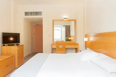 a bedroom with a bed and a desk and a television at Athinais Hotel in Athens