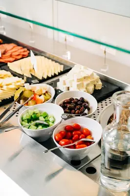 a buffet with bowls of vegetables and other foods at Athinais Hotel in Athens