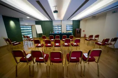 a conference room with red chairs and a table at Athinais Hotel in Athens