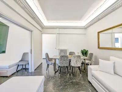 a living room with a table and chairs and a couch at Acropolis View Dream Apartments in Athens