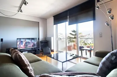 a living room with a couch and a tv at Acropolis Tony's Penthouse in Athens