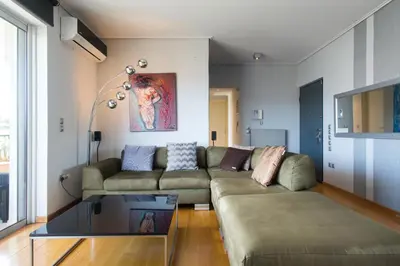 a living room with a couch and a glass table at Acropolis Tony's Penthouse in Athens