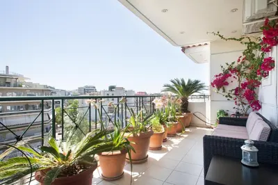 a balcony with lots of potted plants on it at Acropolis Tony's Penthouse in Athens