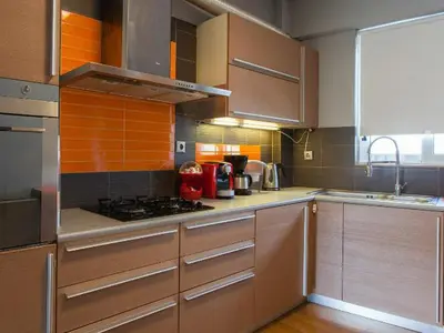 a kitchen with wooden cabinets and a stove top oven at Acropolis Tony's Penthouse in Athens