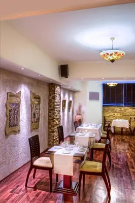 a restaurant with tables and chairs in a room at Nicola Hotel in Athens