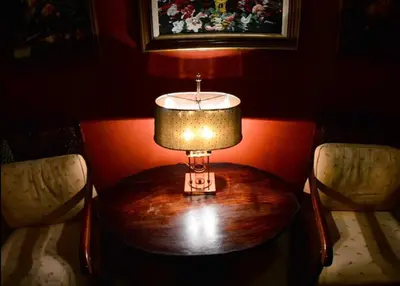 a lamp on a table in a room with two chairs at Nicola Hotel in Athens