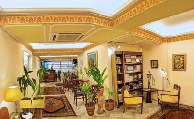 a living room filled with lots of furniture and plants at Nicola Hotel in Athens