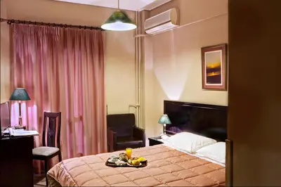 a hotel room with a bed with a tray of food on it at Nicola Hotel in Athens