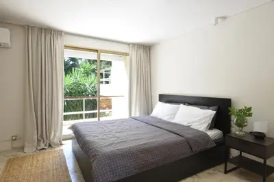 a bedroom with a bed and a large window at Kavouri Flat in Athens