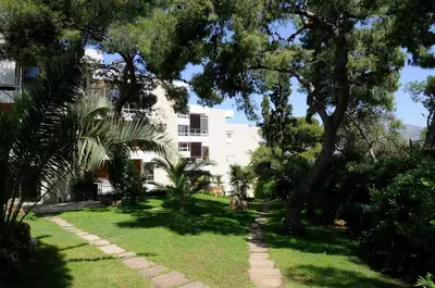 a garden in front of a white building at Kavouri Flat in Athens