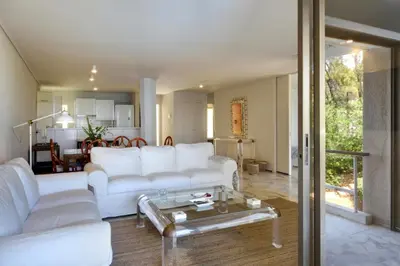 a living room with a white couch and a table at Kavouri Flat in Athens