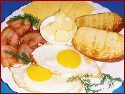 a plate of breakfast food with eggs bacon and toast at Svetlana & Michalis Oasis Hotel in Agia Marina Aegina