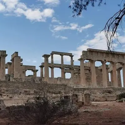 an ancient building with columns on a cloudy sky at Svetlana & Michalis Oasis Hotel in Agia Marina Aegina