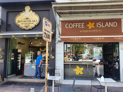 a man standing in front of a coffee shop at Pedion Areos Park 4 Center 4 in Athens