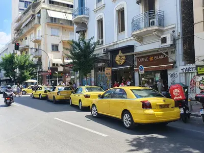 a row of yellow taxis parked on a city street at Pedion Areos Park 4 Center 4 in Athens