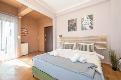 a bedroom with a large bed and a large window at Studio Under Acropolis Rock in Athens