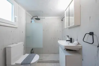a white bathroom with a toilet and a sink at Studio Under Acropolis Rock in Athens